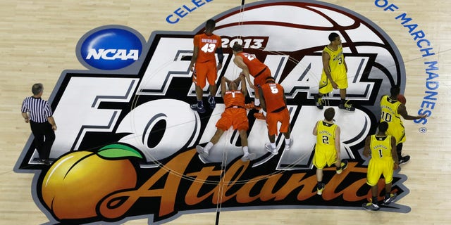 Syracuse's Michael Carter-Williams (1) lies on the court as Syracuse's Brandon Triche (20) helps him during the second half of the NCAA Final Four tournament college basketball semifinal game against Michigan, Saturday, April 6, 2013, in Atlanta. (AP Photo/David J. Phillip)