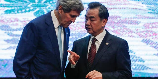 U.S. Secretary of State John Kerry, left, and Chinese Foreign Minister Wang Yi, chat after the group photo session before the East Asia Summit Foreign Ministers' Meeting in Kuala Lumpur, Malaysia on Thursday, Aug. 6, 2015. (AP Photo/Joshua Paul)