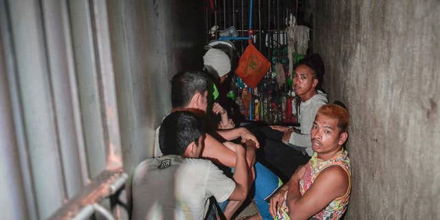 In this Thursday, April 27, 2017 photo, detainees crouch on the floor inside a secret jail after being discovered by the Commission on Human Rights at Police Station 1 at Tondo district in Manila, Philippines. Philippine police relieved a station chief and his staff on Friday after human rights representatives discovered the secret jail cell inside the Manila station where a dozen detainees complained they were being held for extortion. (AP Photo/Ezra Acayan)