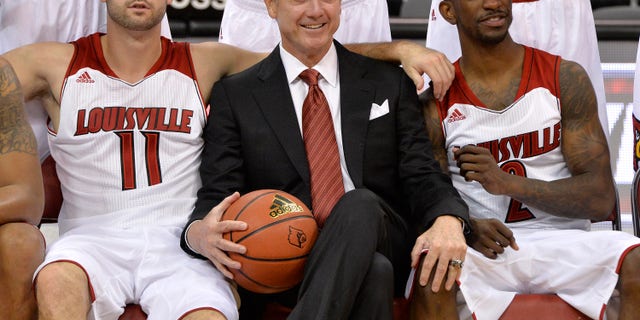 Louisville's Luke Hancock, left, head coach Rick Pitino, center, and Russ Smith pose for the cameras during NCAA college basketball media day, Saturday, Oct. 12, 2013, in Louisville, Ky. (AP Photo/Timothy D. Easley)