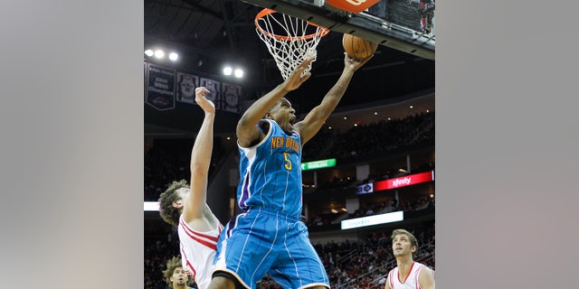 New Orleans Hornets small forward Dominic McGuire (5) drives to the basket for a layup past Houston Rockets center Omer Asik (3) during the first half of an NBA basketball game on Wednesday, Jan. 2, 2013, in Houston. (AP Photo/Bob Levey)