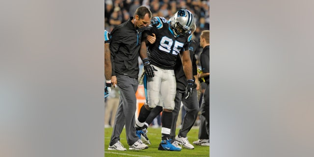 Carolina Panthers' Charles Johnson (95) is helped off the field after being injured against the New England Patriots during the second half of an NFL football game in Charlotte, N.C., Monday, Nov. 18, 2013. (AP Photo/Mike McCarn)