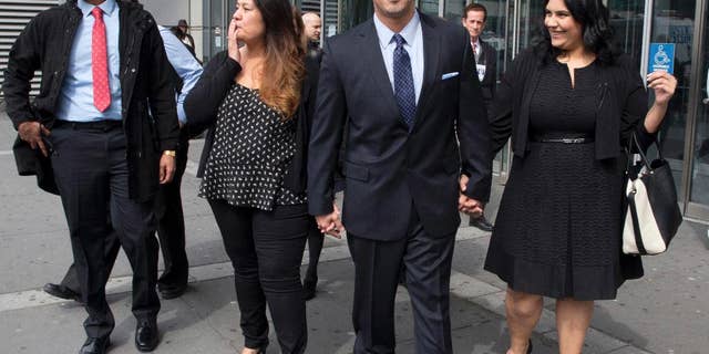 FILE- In this March 23, 2016 file photo, Richard Rosario, center, is joined by his daughter Amanda, right, son Richard Jr., left, and wife Minerva as he leaves Bronx state Supreme Court in New York after his conviction was overturned. Rosario, who spent 20 years in prison for a killing he says happened while he was in Florida, made an unusual request to keep his case open for more investigation, with hopes that newfound evidence would support is claim of innocence, not just that his ex-lawyers erred, but a judge said no. (AP Photo/Mary Altaffer, File)