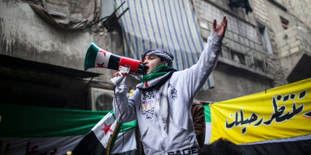 A child uses a megaphone to lead others in chanting Free Syrian Army slogans during a demonstration in the neighborhood of Bustan Al-Qasr, Aleppo, Syria, Friday, Jan. 4, 2013. The U.N. said Wednesday that more than 60,000 people have been killed since Syria's crisis began in March 2011 — a figure much higher than previous opposition estimates. (AP Photo/Andoni Lubaki)
