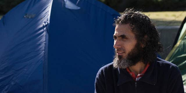 FILE - In this May 5, 2015 file photo, former Guantanamo detainee Abu Wa'el Dhiab, from Syria, sits in front of the U.S. embassy while visiting former fellow detainees demanding financial assistance from the U.S., in Montevideo, Uruguay. Uruguay’s government is offering to bring Dhiab's family to the South American country so they can reunite. The Uruguayan foreign ministry said in a letter Tuesday, Oct. 11, 2016 that the visas and expenses to bring Dhiab’s family have been approved.  (AP Photo/Matilde Campodonico)
