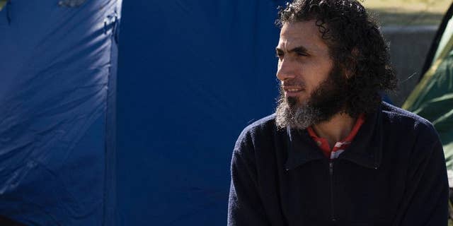 FILE - In this May 5, 2015 file photo, former Guantanamo detainee Abu Wa'el Dhiab, from Syria, sits in front of the U.S. embassy while visiting former fellow detainees demanding financial assistance from the U.S., in Montevideo, Uruguay. Uruguay’s government is offering to bring Dhiab's family to the South American country so they can reunite. The Uruguayan foreign ministry said in a letter Tuesday, Oct. 11, 2016 that the visas and expenses to bring Dhiab’s family have been approved. (AP Photo/Matilde Campodonico)