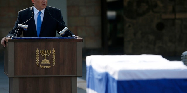 Israel's PM Benjamin Netanyahu speaks near the coffin of former PM Ariel Sharon during a memorial ceremony for Sharon in Jerusalem on Jan. 13, 2014.