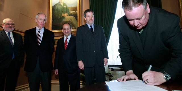 Vermont Technical College President Phil Conroy, right, signs a memorandum of understanding to create the Vermont Higher Education Food Systems Consortium on Thursday, Nov. 7, 2013, in Montpelier, Vt. The institutions plan to share courses in agriculture and food so that students enrolled at one school can take a course, do research or get an internship at another college. Looking on are, from left, Vermont State Colleges Chancellor Tim Donovan, University of Vermont President Thomas Sullivan, Vermont Law School Dean Marc Mihaly and Sterling College President Matthew Allen Derr. (AP Photo/Toby Talbot)