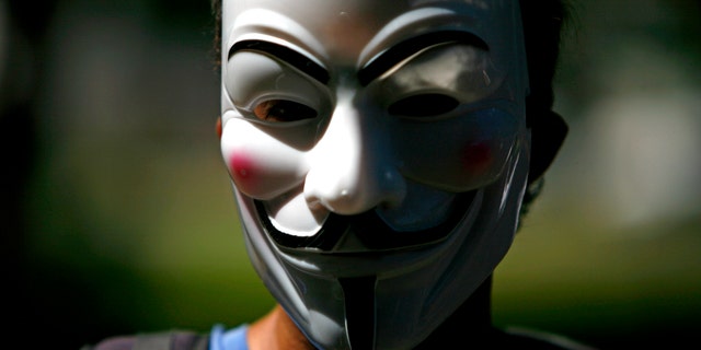 A masked demonstrator protests for Occupy Puerto Rico in San Juan, Puerto Rico, Sunday, Oct. 15, 2011. About 200 people in Puerto Rico have gathered in a financial district dubbed "The Golden Mile" to protest capitalism and government cuts as part of worldwide demonstrations. (AP Photo/Ricardo Arduengo)