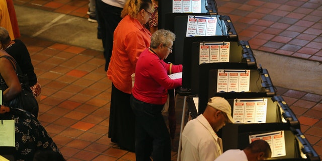 MIAMI, FL - OCTOBER 27: Early voters fill out their ballots as they cast their vote in the presidential election on the first day of early voting, at the Stephen P. Clark Government Center on October 27, 2012 in Miami, Florida. Early voting in one of the important swing states is held for eight straight 12-hour days, leading up to the November 6 general election. (Photo by Joe Raedle/Getty Images)