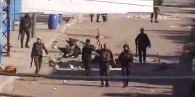 DEC. 19: In this image from TV shown on the internet made available by the Sham News Network, is believed to be soldiers walking down the street in Daraa, Syria.