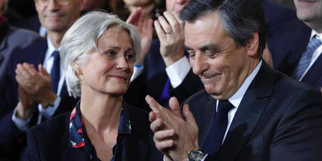 Conservative presidential candidate Francois Fillon applauds while his wife Penelope looks on as they attend a campaign meeting in Paris, Sunday, Jan. 29, 2017. Financial prosecutors are investigating an allegedly fake but handsomely paid job held by the former prime minister's wife, Penelope. (AP Photo/Christophe Ena)