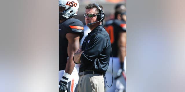 Oklahoma State head coach Mike Gundy watches from the sidelines in the fourth quarter of an NCAA college football game against Iowa State in Stillwater, Okla., Saturday, Oct. 4, 2014. Oklahoma State won 37-20. (AP Photo/Sue Ogrocki)