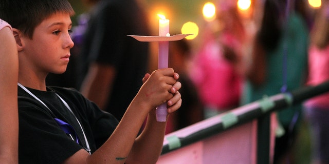 In this Tuesday, April 30, 2013, photo, student Elliott Berry, 8, attends a memorial vigil for slain 8-year-old girl Leila Fowler at Jenny Lind Elementary School in Valley Springs, Calif. (AP Photo/The Modesto Bee, Elias Funez)