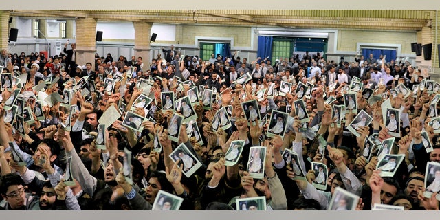 In this photo released by the official website of the Iranian supreme leader's office, Iranian well wishers attending the speech of Supreme Leader Ayatollah Ali Khamenei hold up his picture at a mosque inside the leader's housing compound in Tehran, Iran, Saturday, Feb. 16, 2013. Khamenei said Saturday that his country is not seeking nuclear weapons, but that no world power could stop Tehran's access to an atomic bomb if it intended to build one. (AP Photo/Office of the Supreme Leader)