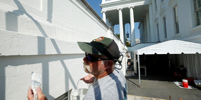 U.S. Park Service employer paints the White House during a renovation in Washington, August 2017.