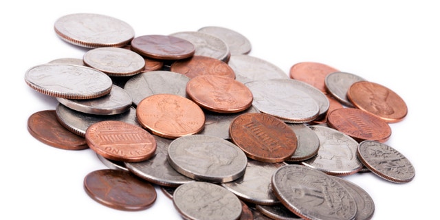 A pile of various American coins (quarters, dimes, nickels, pennies) isolated on white background.