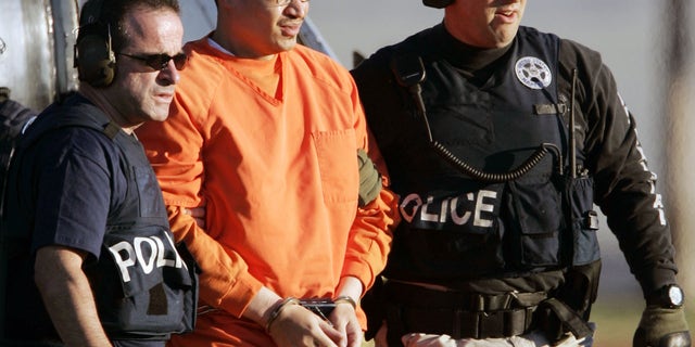 FILE - In this Jan. 5, 2006, file photo, Jose Padilla, center, is escorted by federal marshals on his arrival in Miami. Miami U.S. District Judge Marcia Cooke scheduled a Wednesday afternoon Feb. 12, 2014 hearing for Padilla. He originally was sentenced to 17 years of prison for terrorism support and conspiracy convictions. A federal appeals court ruled in 2011 that the sentence was too lenient, given Padilla's lengthy criminal record and terrorist training at an al-Qaida camp in Afghanistan.(AP Photo/Alan Diaz, File)