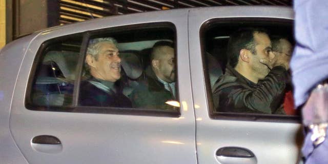 Portugal's former Prime Minister Jose Socrates, in the back seat of the car on the left, leaves a court in a Portuguese police car after being questioned, in Lisbon, Sunday, Nov. 23, 2014. Jose Socrates is spending a third straight night in jail as officials continue to investigate him for suspected corruption, money-laundering and tax fraud. (AP Photo/Francisco Seco)