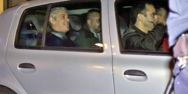Portugal's former Prime Minister Jose Socrates, in the back seat of the car on the left, leaves a court in a Portuguese police car after being questioned, in Lisbon, Sunday, Nov. 23, 2014. Jose Socrates is spending a third straight night in jail as officials continue to investigate him for suspected corruption, money-laundering and tax fraud. (AP Photo/Francisco Seco)