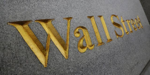 FILE - In this Oct. 2, 2014, file photo, Wall Street is etched in the facade of a building in New York's Financial District. The U.S. stock market is opening sharply lower, Tuesday, Jan. 27, 2015, following disappointing corporate earnings and weak economic news. (AP Photo/Richard Drew, File)