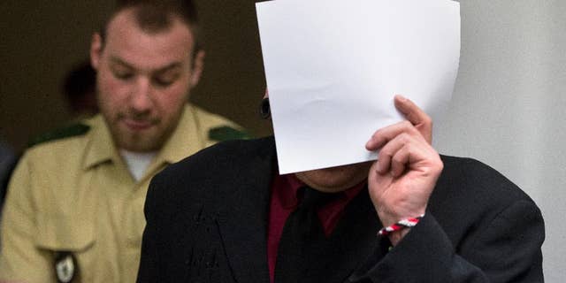 April 27, 2016: Member of the right-wing terror group Oldschool Society Markus W. (no second name given due to German law) covers his face as he is led into a courtroom in Munich, southern Germany. (The Associated Press)