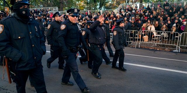 New York Police Department officers are greeted by people before the start of the Macy's Thanksgiving Day Parade in New York, Thursday, Nov. 23, 2017.