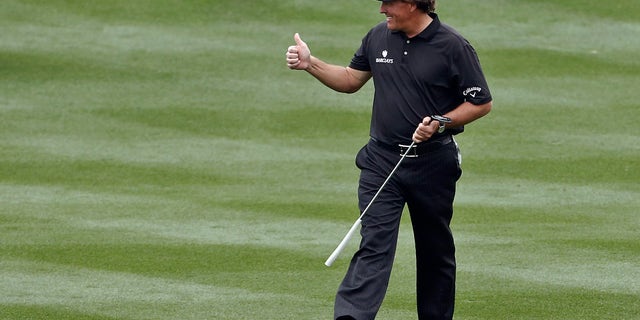 Phil Mickelson gives a thumbs-up to the cheering crowd as he walks up the 18th fairway during the final round of the Waste Management Phoenix Open golf tournament on Sunday, Feb. 3, 2013, in Scottsdale, Ariz. (AP Photo/Ross D. Franklin)