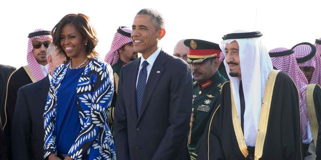 President Barack Obama and first lady Michelle Obama stand with new Saudi King Salman bin Abdul Aziz they arrive on Air Force One at King Khalid International Airport, in Riyadh, Saudi Arabia, Tuesday, Jan. 27, 2015. (AP Photo/Carolyn Kaster)