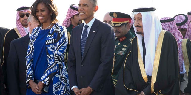 President Barack Obama and first lady Michelle Obama stand with new Saudi King Salman bin Abdul Aziz they arrive on Air Force One at King Khalid International Airport, in Riyadh, Saudi Arabia, Tuesday, Jan. 27, 2015. (AP Photo/Carolyn Kaster)