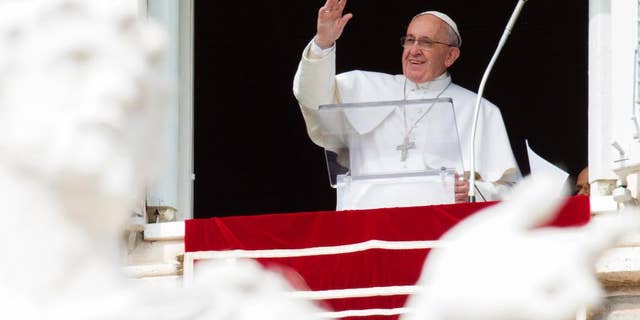 Pope Francis waves to faithful from his studio window overlooking St. Peter's Square, during the Angelus noon prayer at the Vatican, Sunday, Feb. 22, 2015. Francis told tens of thousands of Romans, tourists and pilgrims in St. Peter's Square that later Sunday he and top aides were starting a spiritual renewal retreat. Until Friday morning, they will spend time listening to reflections, meditating and praying in Ariccia, a Rome suburb. (AP Photo/Riccardo De Luca)