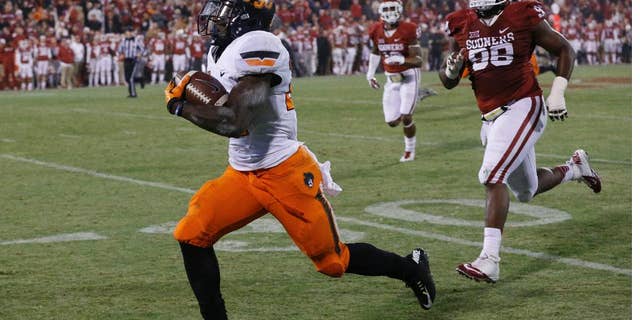 Oklahoma defensive tackle Chuka Ndulue (98) chases as Oklahoma State wide receiver Tyreek Hill, left, runs a punt return 91 yards for a touchdown in the fourth quarter of an NCAA college football game, tying the score and setting up an overtime, in Norman, Okla., Saturday, Dec. 6, 2014. Oklahoma State won 38-35 in overtime. (AP Photo/Sue Ogrocki)