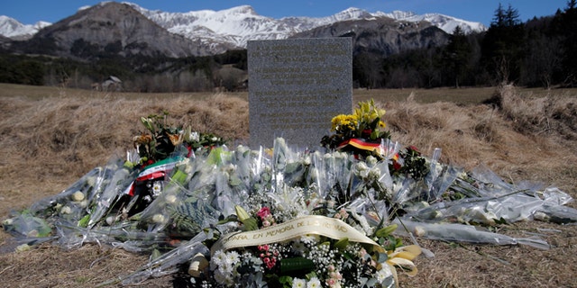 A stele and flowers laid in memory of the victims are placed in the area where the Germanwings jetliner crashed in the French Alps, in Le Vernet, France, Friday, March 27, 2015. The crash of Germanwings Flight 9525 into an Alpine mountain, which killed all 150 people aboard, has raised questions about the mental state of the co-pilot. Authorities believe the 27-year-old German deliberately sought to destroy the Airbus A320 as it flew Tuesday from Barcelona to Duesseldorf. (AP Photo/Christophe Ena)