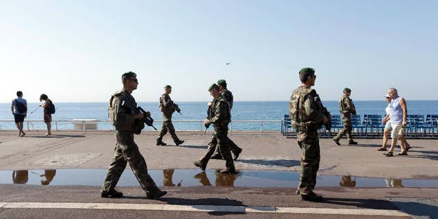 Soldiers patrol on the famed Promenade des Anglais in Nice, southern France, Tuesday, July 19, 2016. Joggers, cyclists and sun-seekers are back on Nice's famed Riviera coast, a further sign of normal life returning on the Promenade des Anglais where dozens were killed in last week's Bastille Day truck attack. (AP Photo/Claude Paris)