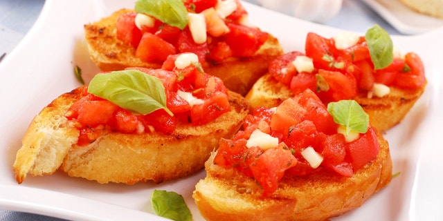 italian bruschetta with tomato,basil and cheese on purple plate