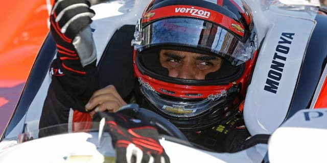 Juan Pablo Montoya, of Colombia, puts on his gloves as he prepares to drive on the final day of practice for the Indianapolis 500 IndyCar auto race at the Indianapolis Motor Speedway in Indianapolis, Friday, May 23, 2014. The 98th running of the Indianapolis 500 is Sunday. (AP Photo/Michael Conroy)