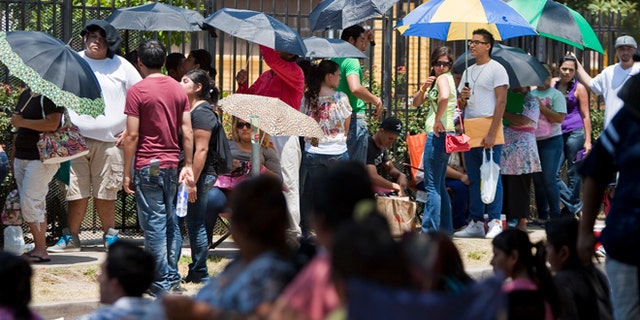 Illegal immigrants wait in line to get passports outside the Mexican Consulate in Houston in August, after the Department of Homeland Security began accepting applications to allow them to avoid deportation. (AP)