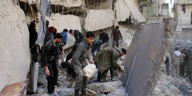 In this citizen journalism image provided by Aleppo Media Center (AMC), an anti-Bashar Assad activist group, which has been authenticated based on its contents and other AP reporting, Syrians inspect the rubble of destroyed buildings following a Syrian government airstrike in Aleppo, Syria, Friday, Jan. 31, 2014 . Activists said the latest Syrian government shelling has killed and wounded several people in a rebel-held area of the northern city of Aleppo. (AP Photo/Aleppo Media Center, AMC)