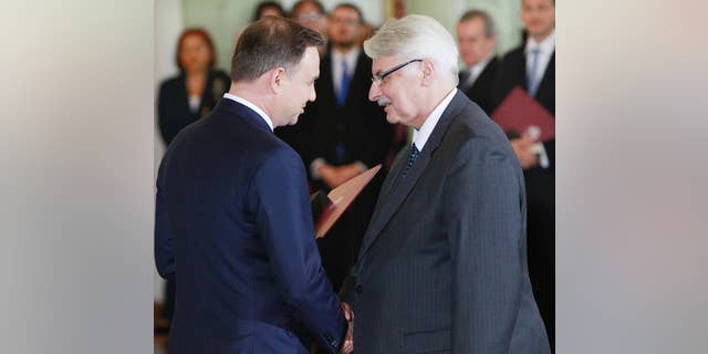 FILE - In this Nov.16, 2015 file photo Poland's President Andrzej Duda , left, congratulates Witold Waszczykowski as he is sworn in as new Polish Foreign Minister during the swearing-in ceremony of the new, conservative government at the Presidential Palace in Warsaw, Poland. Waszczykowski told The Associated Press he welcomes the new cooperation between Russia and the West in the fight against the Islamic State group, but insists that Ukraine's interests cannot be sacrificed as a reward to Moscow for those efforts. (AP Photo/Czarek Sokolowski)