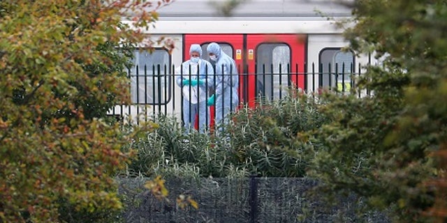 Investigators search next to a train at Parsons Green station in London.