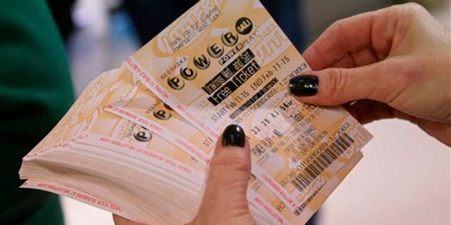 A lottery representative hands out free Powerball tickets at Russ's Market in Lincoln, Neb., as part of a promotion, Wednesday, Feb. 11, 2015. The Powerball jackpot has climbed to an estimated $500 million, which would make it the fifth largest lottery prize in U.S. history.