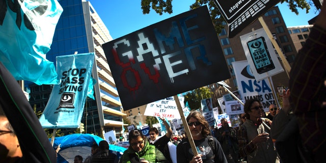 WASHINGTON, DC - OCTOBER 26, 2013: Protesters march through downtown Washington D.C. during the Stop Watching Us Rally protesting surveillance by the U.S. National Security Agency, on October 26, 2013, in front of the U.S. Capitol building in Washington, D.C. The rally began at Union Station and included a march that ended in front of the U.S. Capitol building and speakers such as author Naomi Wolf and former senior National Security Agency senior executive Thomas Drake. (Photo by Allison Shelley/Getty Images)
