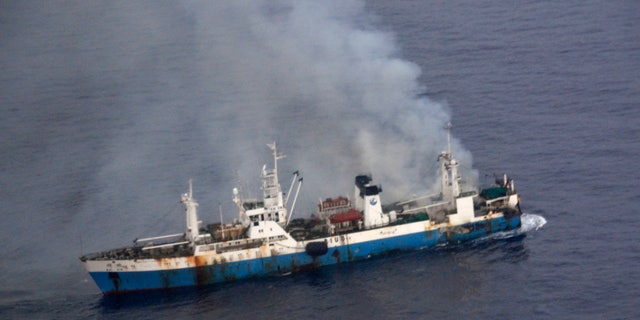 In this picture released by Chile's Air Force, smoke billows from a Chinese factory fishing ship Kai Xin just off the coast of Antarctica, Wednesday, April 17, 2013. Chilean authorities say around 90 crew members have been rescued from the burning ship by the crew of the Norwegian ship Juvel, and Chile’s military says it’s ready to intervene if necessary to prevent an ecological disaster. (AP Photo/Chile's Air Force)
