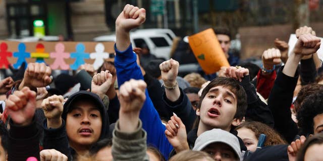 Students from high schools and colleges throughout New York city protest with clenched fists, during a rally against President Donald Trump's executive order banning travel from seven Muslim-majority nations, Tuesday Feb. 7, 2017, in New York's Foley Square. (AP Photo/Bebeto Matthews)