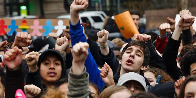 Students from high schools and colleges throughout New York city protest with clenched fists, during a rally against President Donald Trump's executive order banning travel from seven Muslim-majority nations, Tuesday Feb. 7, 2017, in New York's Foley Square. (AP Photo/Bebeto Matthews)