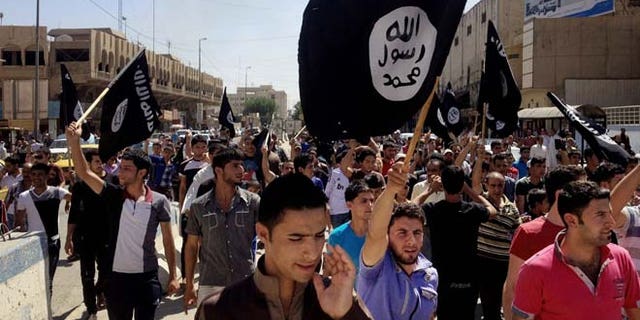 June 16, 2014: Demonstrators chant pro-Islamic State group slogans as they carry the group's flags in front of the provincial government headquarters in Mosul, 225 miles northwest of Baghdad.