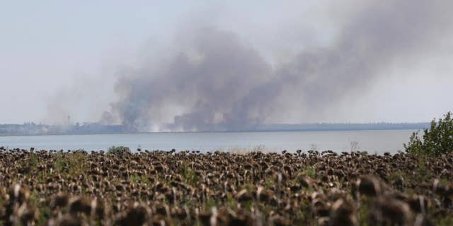 Aug. 26, 2014: Smoke rises after shelling in the town of Novoazovsk, eastern Ukraine. Towering columns of smoke rose Tuesday from outside a city in Ukraine's far southeast after what residents said was a heavy artillery barrage.