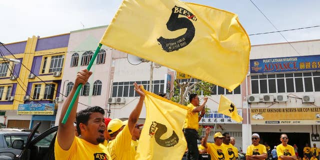 In this Oct. 15, 2016 photo, pro-democracy activists wave "Bersih 5" flags in Sekinchan, Malaysia. Malaysian pro-democracy activists have vowed to go ahead with a massive rally on Saturday, Nov. 19 to demand Prime Minister Najib Razak's resignation over a financial scandal despite a police ban and fears of clashes with a pro-government group. Chairwoman Maria Chin of Bersih says Saturday's rally in downtown Kuala Lumpur will protest poor governance and a lack of accountability that have led to "grand corruption" in the 1MDB fund. (AP Photo/Lim Huey Teng)