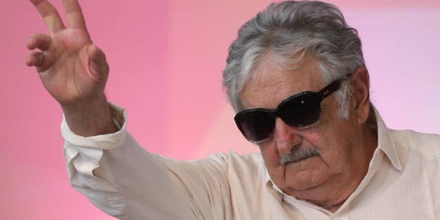 FILE - In this Dec. 16, 2015 file photo, Uruguay's former President Jose Mujica waves to the crowd during the opening of the National Youth Conference, in Brasilia, Brazil. Mujica says Venezuelan President Nicolas Maduro is “crazy as a goat,” while speaking Wednesday, May 18, 2016, at a press conference where he was asked about an escalating row between Maduro and the head of the Organization of American States. (AP Photo/Eraldo Peres, File)