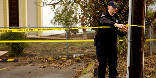 CORVALLIS, OR - NOVEMBER 28: A Corvallis police officer puts up police tape in front of the Salman Al Farisi Islamic Center on November 28, 2010 in Corvallis, Oregon. An arsonist set fire to the prayer center, which was sometimes attended by suspected Portland car bomber Mohamed Osman Mohamud. Mohamud, a Somali-born teenager, was arrested and charged with attempted use of a weapon of mass destruction when  he allegedly attempted to set off a car bomb during Christmas tree lighting ceremony in Pioneer Courthouse Square in Portland, Oregon. It was reported that civilians were not at risk because the bomb was supplied to him by undercover federal agents and the explosives were inert.   (Photo by Craig Mitchelldyer/Getty Images)